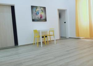 a table and chairs in a room with a painting at Appartamento nuovo a 1 minuto dal porto in Livorno