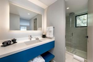 a bathroom with a shower, sink, and tub at La Jolla Cove Suites in San Diego