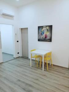 een tafel en stoelen in een kamer met een schilderij bij Appartamento nuovo a 1 minuto dal porto in Livorno