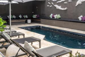 a swimming pool with a pool table and chairs at Byron Bay Hotel and Apartments in Byron Bay