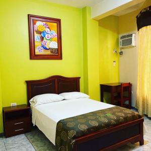 a bedroom with a bed and a painting on the wall at D’ RUIZ HOTEL in Quevedo