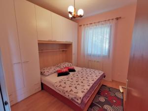 um pequeno quarto com uma cama e uma janela em Apartment Delost em Lovran