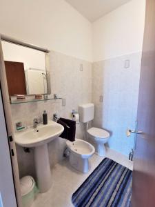 uma casa de banho com um lavatório, um WC e um espelho. em Apartment Delost em Lovran