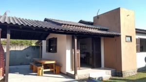 a small building with a table and a bench at Casa bege Bal Arroio do Silva com internet in Arroio do Silva