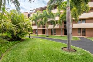 an apartment building with palm trees and a driveway at BeachFront Kihei Kai Nani - Maui Vista Deluxe Condos in Kihei