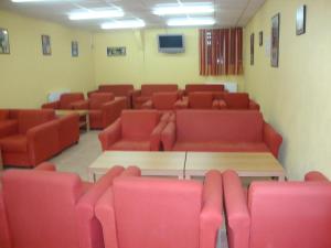- une salle d'attente avec des chaises rouges et une table dans l'établissement Albergue de Peregrinos A Santiago, à Belorado