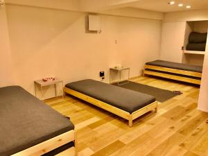 a room with two beds and two tables at Enzo Kyoto Gojo E in Kyoto