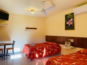 a bedroom with two beds and a table and a sink at Hotel Sociedad y Maristas in Tecolutla