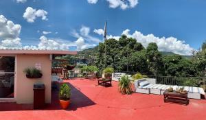a patio with couches and chairs on a building at Palmira Hostel in Tegucigalpa