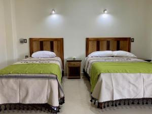 duas camas sentadas uma ao lado da outra num quarto em Lidxi Rosae em Puerto Escondido