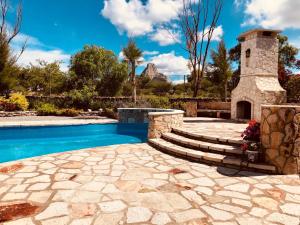 einen Pool mit einem Steinturm neben einem Haus in der Unterkunft Club Vergel Resort in Bernal