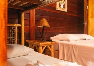 sypialnia z 2 łóżkami i lampką na stole w obiekcie Lonier Nature INN w mieście Abraão