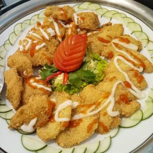 a plate of food with chicken and vegetables on it at Green Red Hotel Syariah Jombang in Jombang