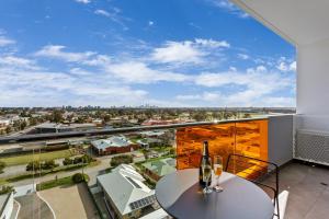 a balcony with a table and two wine glasses on it at Quest Perth Ascot in Perth
