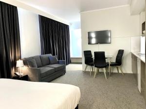 
a living room filled with furniture and a tv at Bannister 22 Hotel in Fremantle
