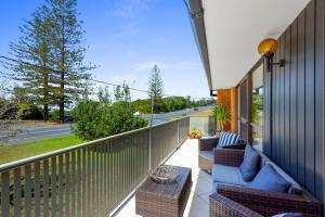a balcony with two chairs and a table on a building at Fi's relaxing Beach House in Port Macquarie