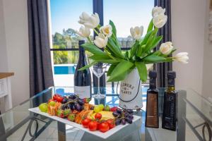 une table recouverte d'un vase de fleurs et de légumes dans l'établissement Mandalay Villas - Villa 2, à Paxton