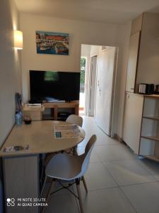 Residence Les Palmiers في نيس: مطبخ وغرفة معيشة مع طاولة وكراسي