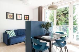 a dining room with a blue couch and a table and chairs at Lion Apartments - Chopina 29 with parking 5 min from the beach and Center in Sopot