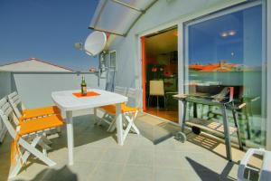 balcón con mesa y sillas blancas en Apartments Rossana, en Poreč