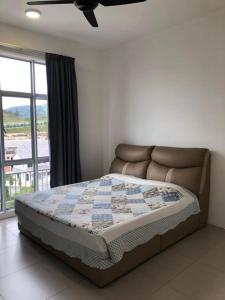 a bed with a quilt on it in a bedroom at Barrington Square 1 Room Apt @ Pasar Malam in Brinchang