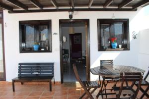 een patio met een tafel en stoelen en een huis bij Casa Vittoria in Playa Honda