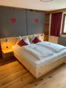 ein Schlafzimmer mit einem großen Holzbett mit Kissen in der Unterkunft Apartment Anita in Ellmau