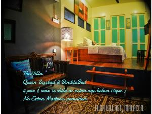Zimmer mit einem Bett, einem Sofa und einer Bank in der Unterkunft Fuga Village BeachGetaway in Malakka