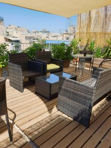 eine Terrasse mit Korbstühlen und einem Tisch auf dem Dach in der Unterkunft Newly Renovated Studio 15 min walk from Acropolis in Athen