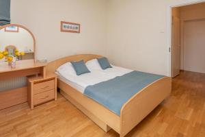 1 dormitorio con cama, escritorio y espejo en Vikondos Poilsio Namai, en Palanga