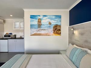 a bedroom with a view of the ocean and two rocks at Apollo Bay Waterfront Motor Inn in Apollo Bay