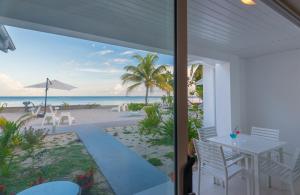 a view of the beach from the porch of a house at Le Nautique Beachfront Apartments in Anse Royale