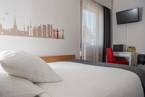 a bedroom with a white bed and a red chair at Hotel Cereda in Sementina