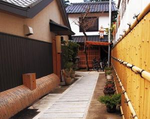 a courtyard of a house with plants and a fence at Machiya Kyoto Shogoin in Kyoto