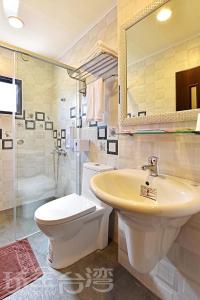 La salle de bains est pourvue d'un lavabo, de toilettes et d'un miroir. dans l'établissement Three days and two nights B&B, à Magong