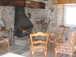 a stone room with two chairs and a fireplace at Holiday cottage in Lozre in a pretty corner of Margeride in Mialanes +2 photos