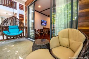a room with a swing chair and a living room at Borneo Divers Mabul Resort in Pulau Mabul 