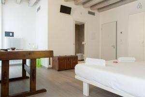 a room with two beds and a desk in it at Residenza Cardo Massimo in Verona