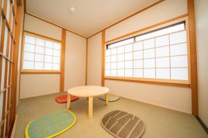 a room with a table and two windows at Pets OK! Hakone Life resort Toki sengokuhara in Hakone