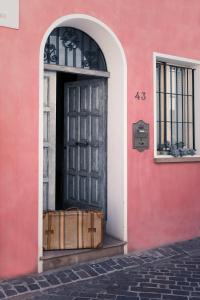 una puerta negra en un edificio rosa con cajas fuera en Cà Tabachera, en Rímini