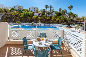 a balcony with a table and chairs and a swimming pool at Hotel Tropical Park in Callao Salvaje