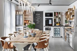 uma cozinha com uma mesa de madeira e cadeiras em Stay KooooK Bern Wankdorf - Online Check In em Berna
