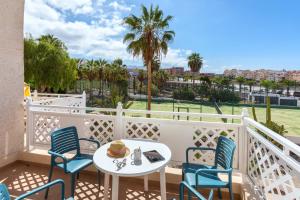 a balcony with a table and chairs and palm trees at Hotel Tropical Park in Callao Salvaje