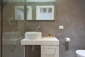 uma casa de banho com um lavatório branco e um espelho. em Residenza Cardo Massimo em Verona