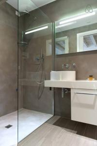 uma casa de banho com uma cabina de duche em vidro e um lavatório. em Residenza Cardo Massimo em Verona
