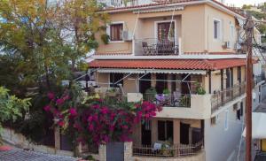 a building with flowers hanging off the side of it at MarGio Skiathos Apartments in Skiathos Town