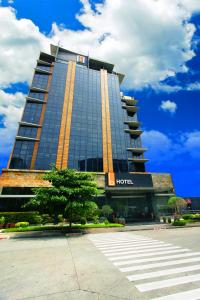 The B Hotel Alabang في مانيلا: مبنى الفندق امامه شجرة