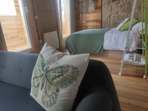 a living room with a butterfly pillow on a couch at Hospédate Pontevedra in Pontevedra