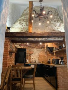 une cuisine avec une table et un mur en briques dans l'établissement Reinhold Apartments, à Rakvere