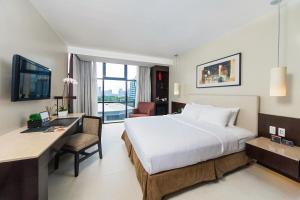 una camera d'albergo con letto e scrivania con computer di The B Hotel Alabang a Manila Altre 25 foto